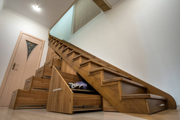 istock Modern architecture interior with luxury hallway with glossy wooden stairs in multi-storey house. Custom built pullout cabinets on glides in slots under stairs. Use of space for storage. 1188903762