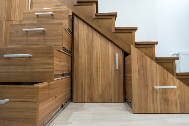 istock Modern architecture interior with luxury hallway with glossy wooden stairs in multi-storey house. Custom built pullout cabinets on glides in slots under stairs. Use of space for storage. 1188903764