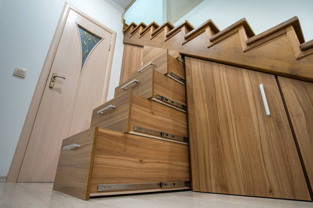 istock Modern architecture interior with luxury hallway with glossy wooden stairs in multi-storey house. Custom built pullout cabinets on glides in slots under stairs. Use of space for storage. 1188903768