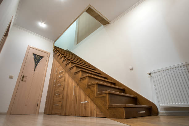 istock Modern architecture interior with luxury hallway with glossy wooden stairs in multi-storey house. Custom built pullout cabinets on glides in slots under stairs. Use of space for storage. 1188903770