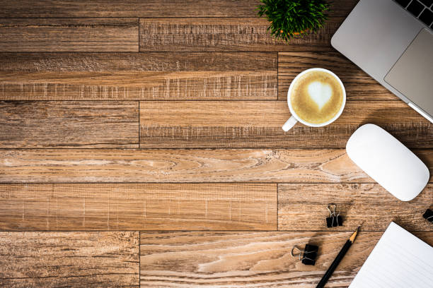 istock The office desk flat lay view with laptop, mouse, tree, black clip, heart latte coffee cup, notebook, pencil on wood texture background. 1188905027