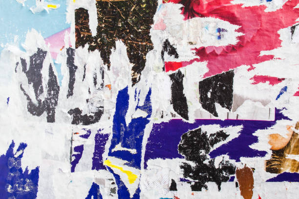 istock Old torn and peeling paper posters on dirty billboard texture background. 1188905116