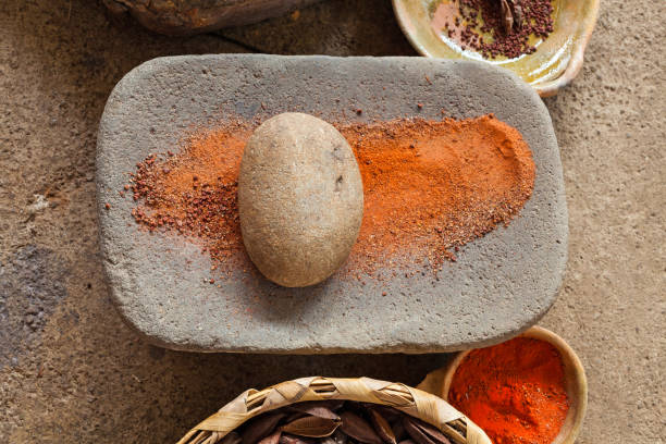 Mealing stone with orange powder. Metate. Traditonal old tool for grinding grain and beans.