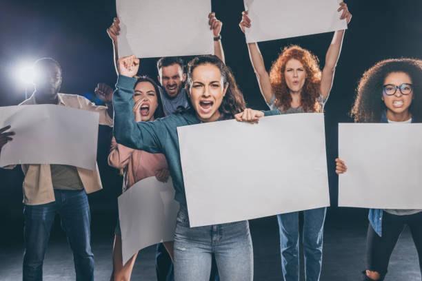 istock emotional multicultural people screaming while holding blank placards on black 1188905656