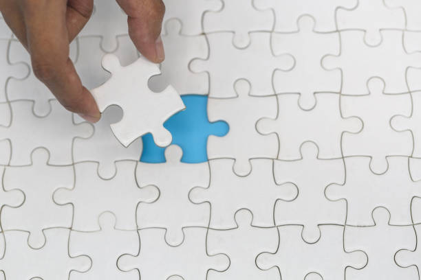 istock Hand placed the last piece of jigsaw puzzle, conceptual of problem solving, finding a solution 1188905916