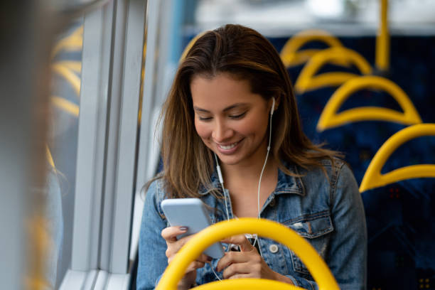 istock Woman social networking on her cell phone while riding the bus 1188910233