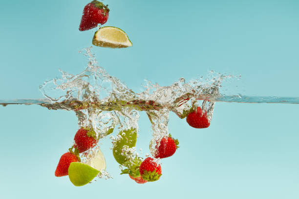 istock lime pieces and strawberries falling deep in water with splash on blue background 1188911600