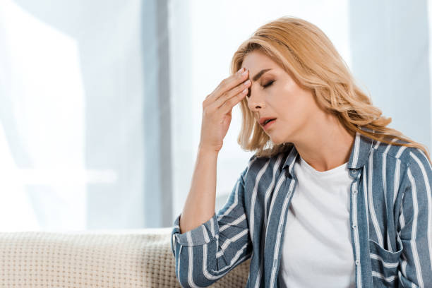 istock upset woman with closed eyes touching head at home 1188912867