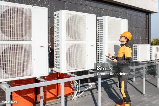 Workman Servicing Air Conditioning Or Heat Pump With Digital Tablet Stock Photo - Download Image Now