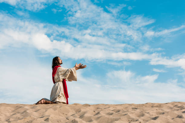 istock jesus praying on knees in desert against sky 1188915771