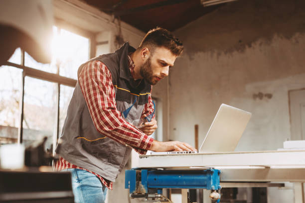 istock Young man work in home workshop using laptop and reads the manual 1188919184
