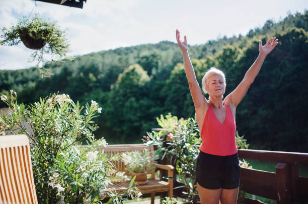 istock A senior woman standing outdoors on a terrace in summer, doing exercise. 1188920686