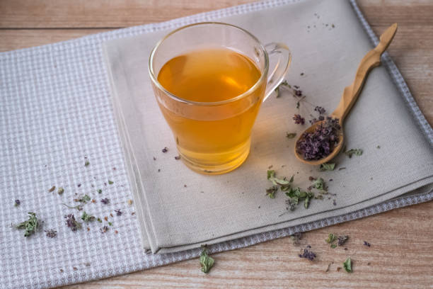 istock Warm oregano tea on beige linen napkins on the table. 1188920735