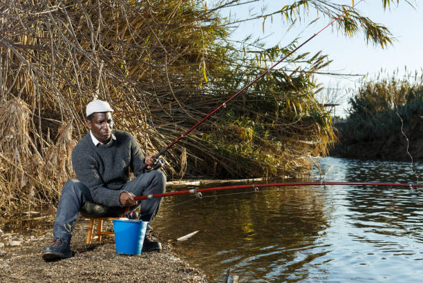 istock Man fishing with rods on river 1188921275