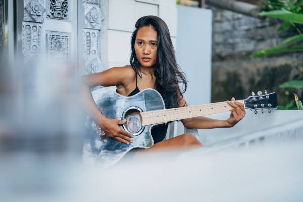 istock Pretty woman playing guitar on home terrace 1188922966