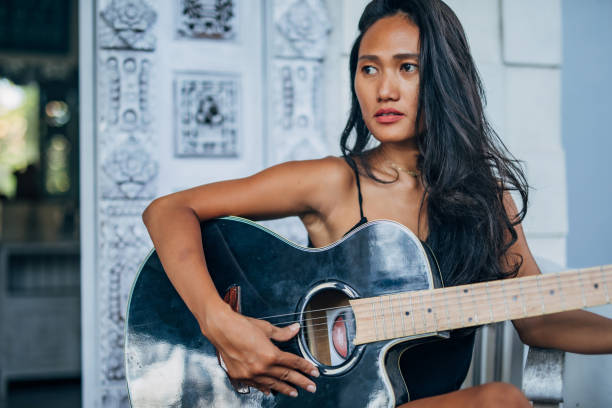 istock Young woman playing guitar on home terrace 1188923814