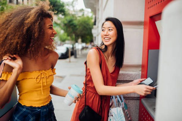 atmマシンからお金を取る女の子 - spending money adult african ethnicity bag ストックフォトと画像