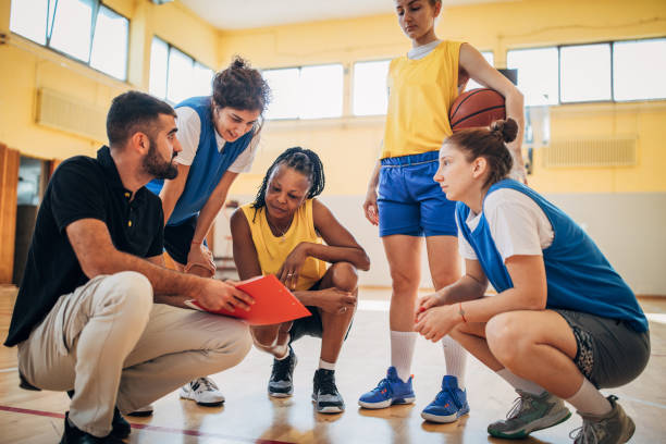 istock Male coach crouching with his basketball team 1188925481