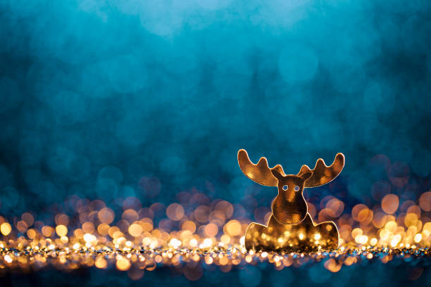 Decorative christmas still life. Abstract reindeer on golden and blue glitter background.