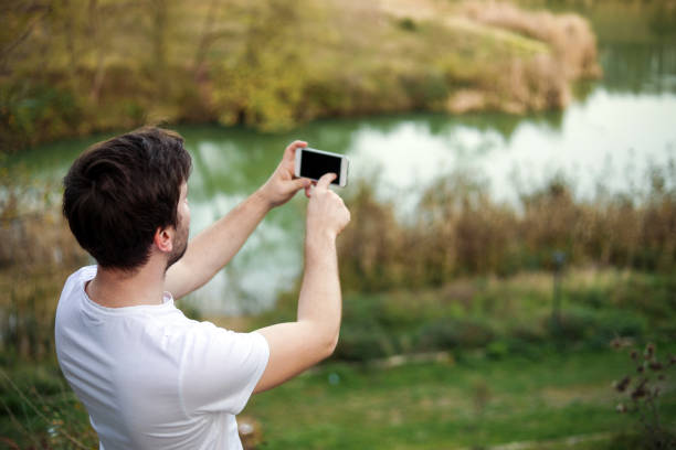 istock young man taking pictures in nature 1188928589