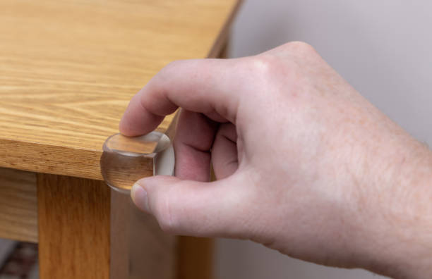 istock Putting a rubber stopper on a table corner - child proofing the home 1188928657