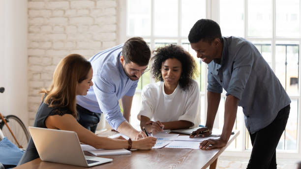istock Smiling mixed race colleagues explaining project ideas to female teammates. 1188929913