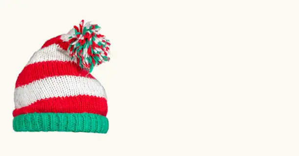 Knitted Christmas hat on a white background. Funny christmas hat. New Year invitation