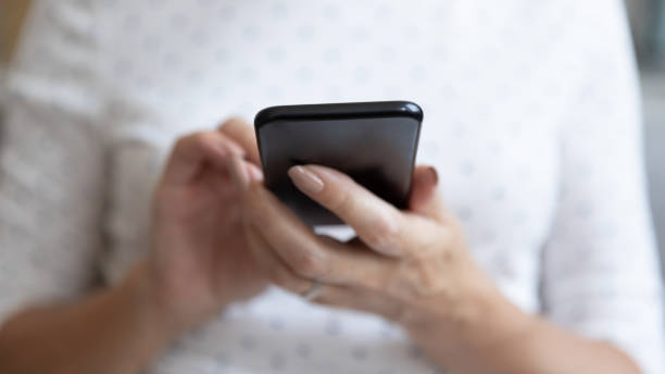 istock Senior woman holding smartphone using mobile app, close up view 1188934086