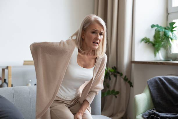 心配動揺成熟した女性は突然の背中の痛みを感じる - arthritis osteoporosis pain backache ストックフォトと画像