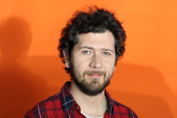 istock Man looking at camera in orange background 1188934960