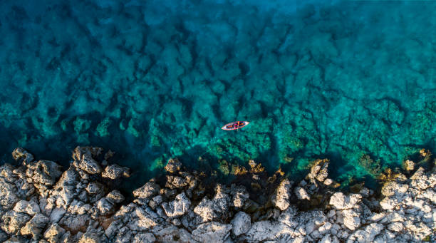 istock Woman kayaking clear turquoise sea 1188938391