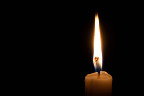 istock a lonely burning candle in the darkness 1188938437