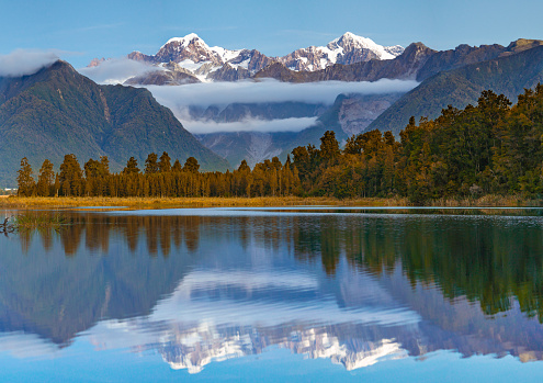Scenic view of Lake Matheson near the Fox Glacier with reflected views of Aoraki Mount Cook and Mount Tasman in South island, New Zealand, The place of tourist attraction and famous of New Zealand.
