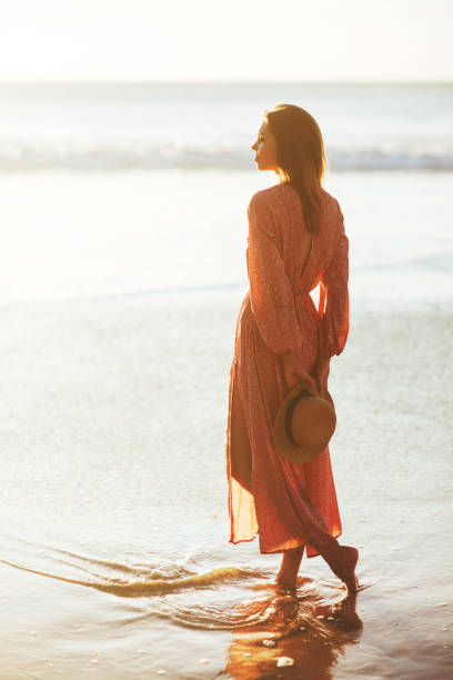 istock young slim beautiful woman on sunset beach 1188942277