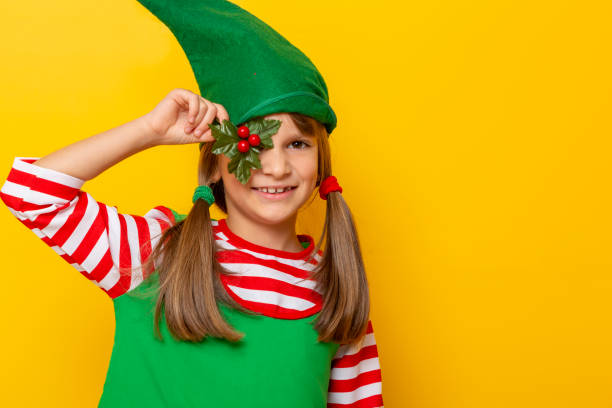 istock Child wearing elf costume holding mistletoe 1188944071