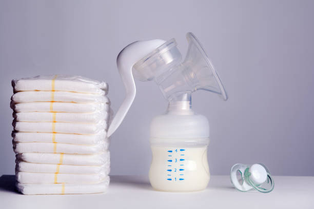 istock breast pump, diapers and baby's pacifier on white 1188948269