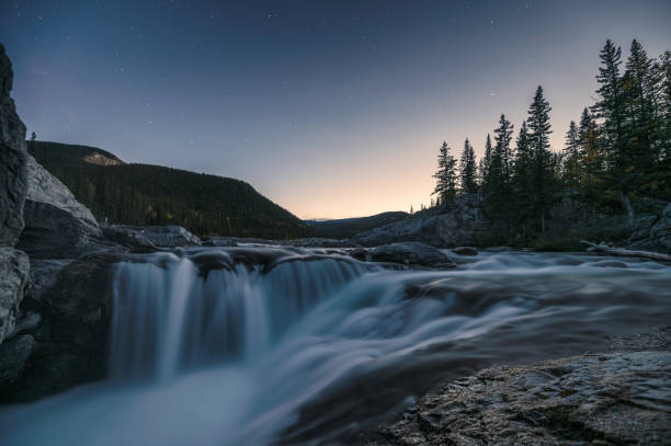 istock Waterfall rapids flowing on rocks in pine forest on evening at Elbow falls 1188948569