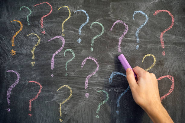 istock Too many questions. Man drawing colorful question marks on a blackboard 1188949873
