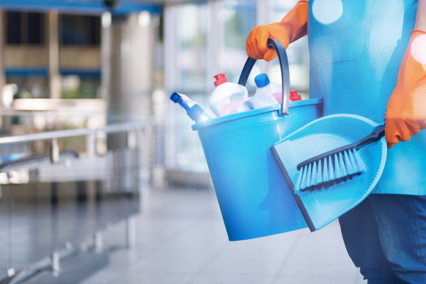 The concept of clening service. The concept of clening service. The cleaning lady stands with a bucket and a shovel on blurred background. hygiene stock pictures, royalty-free photos & images