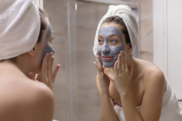 istock Young woman in towel applying mask 1188956745