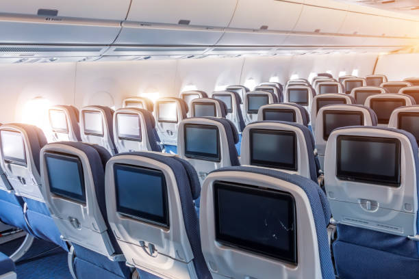 istock Economy class empty seats with entertainment system onboard a wide-body airliner. 1188960100