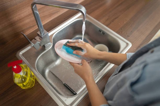 istock Housewife holding a plate under running water 1188960753