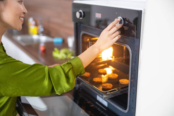 istock Smiling young woman setting the oven timer 1188961536