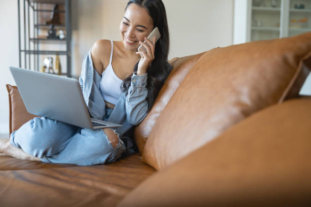 istock Laughing girl sitting on a leather sofa 1188961651