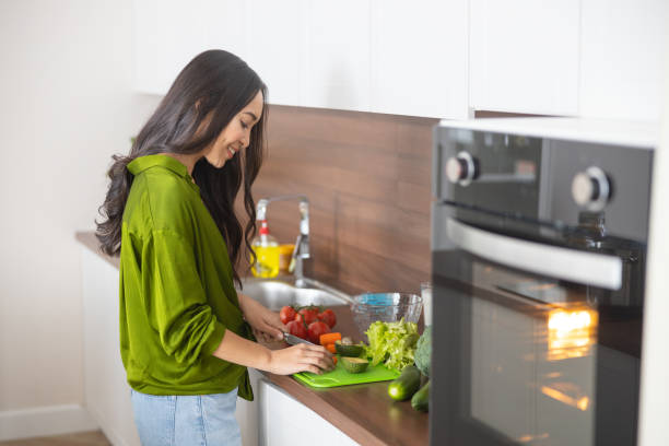 istock Smiling young woman working in the kitchen 1188961845