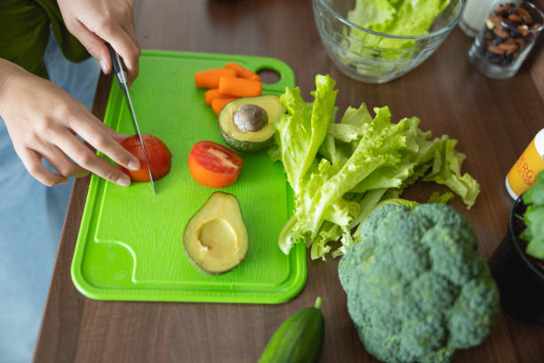istock Young female cook cutting vegetables into pieces 1188961947