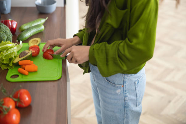 istock Young housewife dicing tomatoes on the board 1188961957