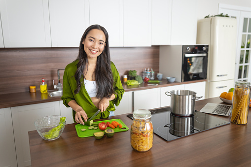Beautiful young Asian female cook posing for the camera
