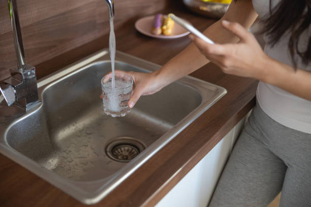 istock Lady drawing fresh water from the faucet 1188962095