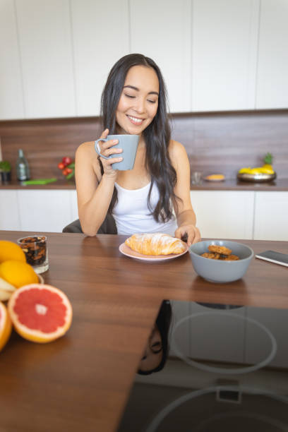 istock Young woman eating alone in the kitchen 1188962177